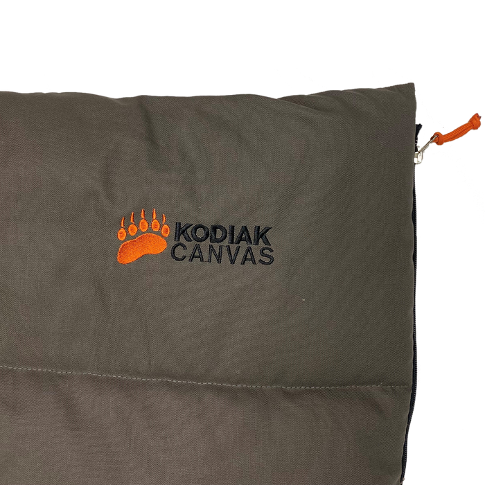 Kodiak Canvas sleeping bag in dark green with orange logo, durable, waterproof, perfect for camping.