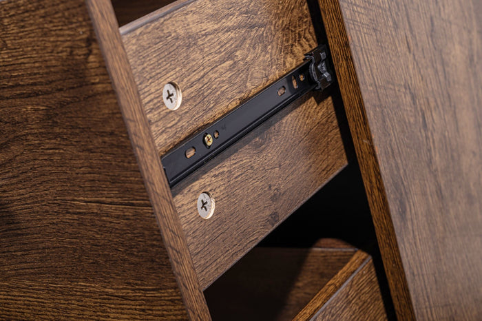 Walnut color 'Althea' bedside table by sue-e furniture with a sleek design and storage drawer, placed beside a bed.