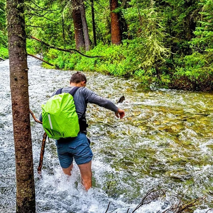 Luminous yellow waterproof backpack cover from 9eight5 protecting a backpack from rain and moisture.