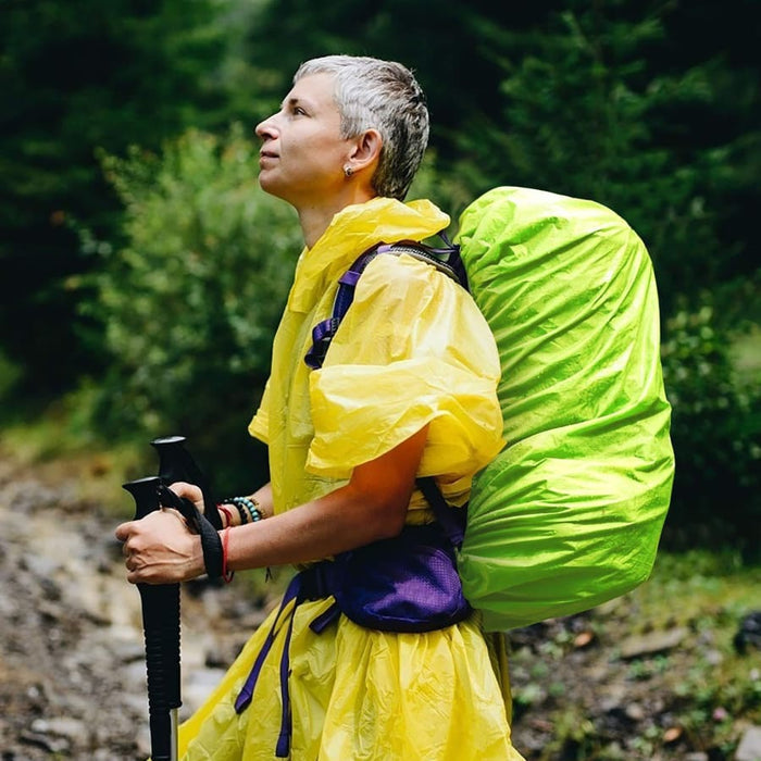 Luminous yellow waterproof backpack cover by 9eight5 protecting a backpack from rain and moisture.