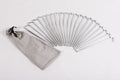 Set of 20 silver metal tent pegs with a gray storage bag for camping and outdoor activities.