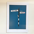 Framed artwork of a street sign with 'Ballymun is in my heart' text on a blue background.