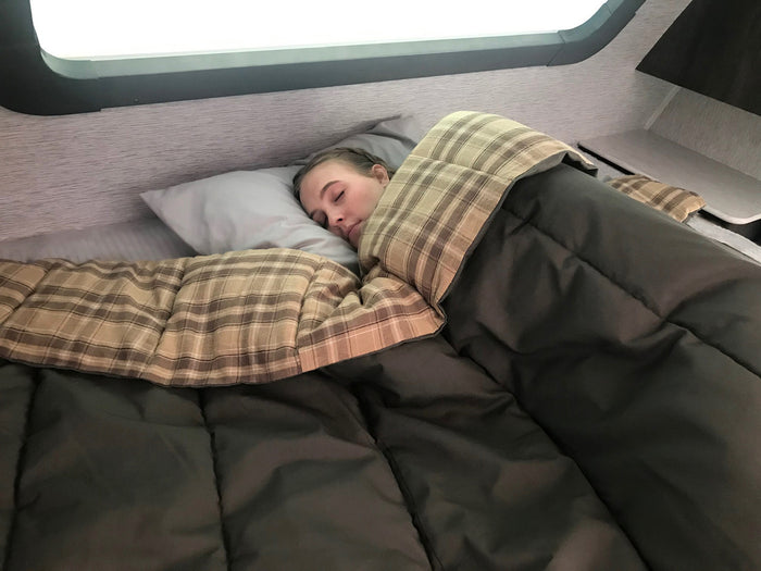 Cozy plaid sleeping bag in earth tones, perfect for camping and outdoor adventures.