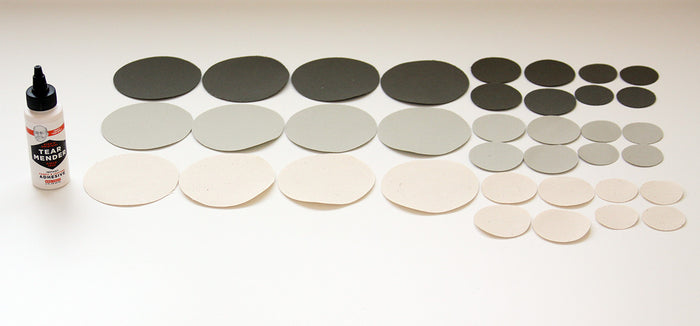 Assorted round fabric patches in gray, black, and beige with Tear Mender adhesive for quick repairs.