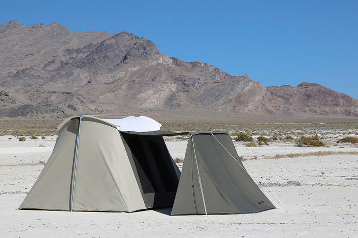 Spacious beige camping tent with a gray rainfly, ideal for outdoor adventures in rugged terrain.