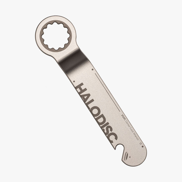 A metallic Centerlock Tool from HALOBLK Store features a serrated circular end for gripping and turning, a flat branded handle, and a small notch near the handle's end for added functionality.