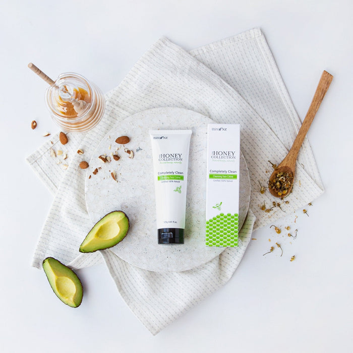 The Honey Collection Completely Clean Purifying Cream Cleanser in a white tube with a pink cap, suitable for gentle face cleansing.