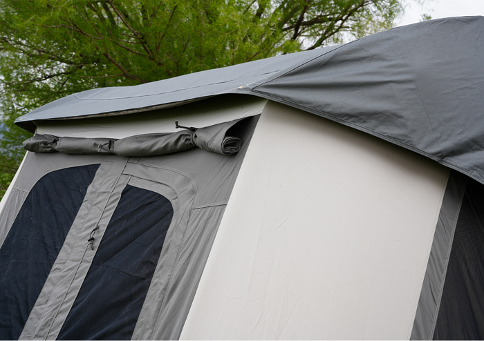 Gray camping tent with durable fabric, featuring a roll-up flap and mesh windows for ventilation.
