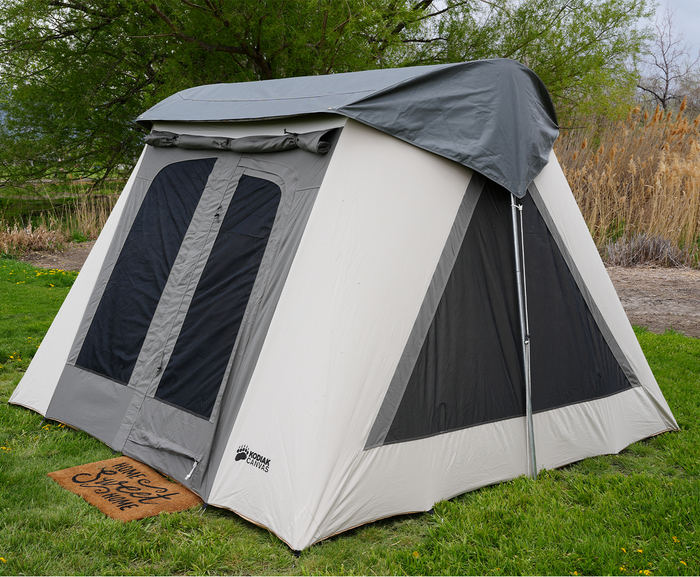 Kodiak Canvas tent in gray and cream, durable material, designed for camping, featuring side windows and a spacious interior.