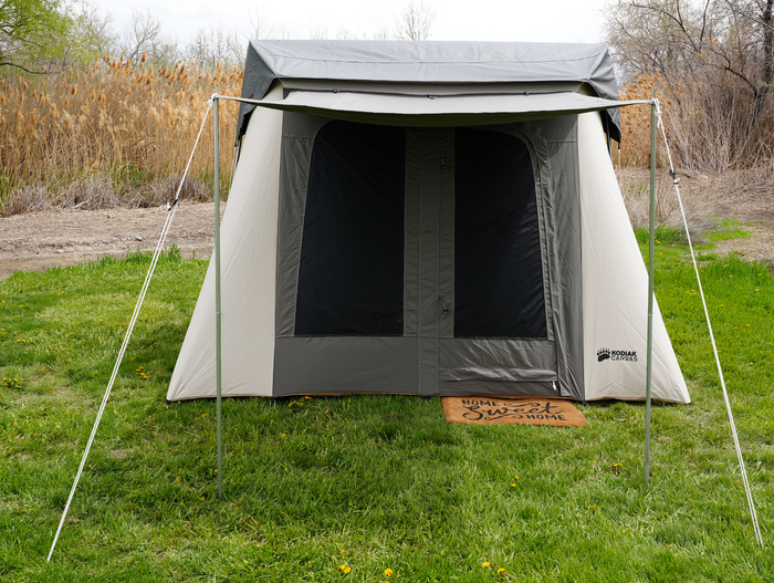 Kodiak Canvas tent in gray, durable cotton material, featuring large windows and a spacious entrance.