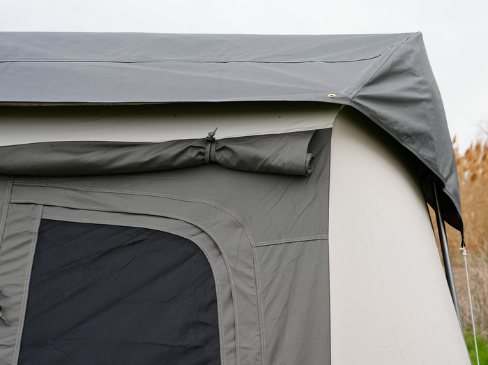 Close-up of a gray camping tent roof highlighting durable fabric and rolled tarp feature.