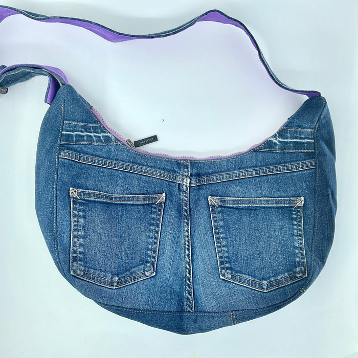 Blue denim handbag with purple trim on a white background