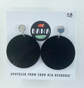 Black round earrings on a Dana brand card with text about upcycling from old records.