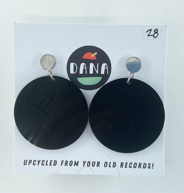 Black round earrings on a Dana brand card with text about upcycling from old records.