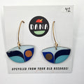 A pair of blue and white geometric patterned earrings on a Dana brand card with the text 'UPCYCLED FROM YOUR OLD RECORDS!'