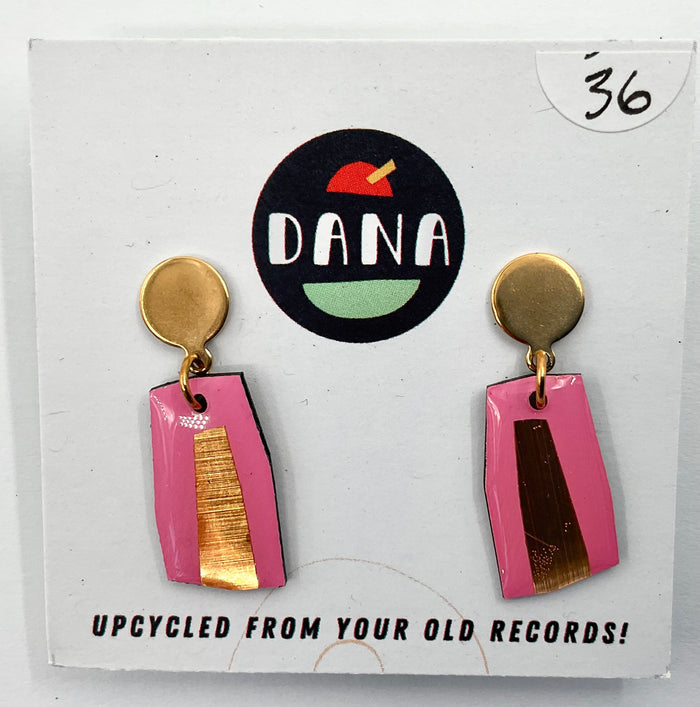 A pair of pink and metallic detailed earrings, with the brand name Dana featured in the background, indicating the earrings are upcycled from old records.