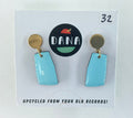 Pair of blue earrings on a card with 'DANA' branding and text about upcycling from old records.