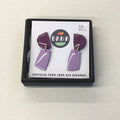A pair of purple and lilac earrings made from upcycled vinyl records, presented in a black box with the brand name 'DANA' on it.