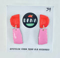Colorful earrings on a card with 'DANA' branding and text about upcycling from old records.
