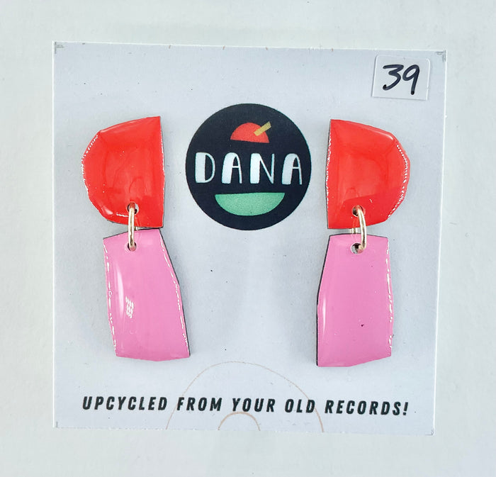 Colorful earrings on a card with 'DANA' branding and text about upcycling from old records.