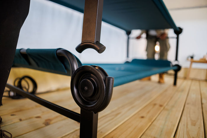 Durable foldable cot with teal fabric, black metal frame, ideal for camping and extra bed needs.
