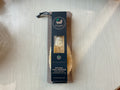 A natural sisal massage hand brush packaged in a brown paper bag with a black label featuring the brand name and product details.