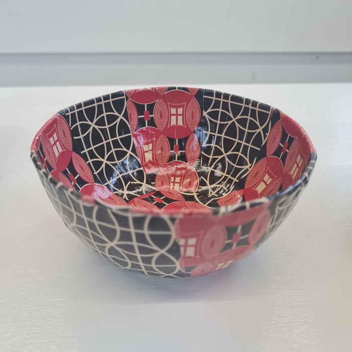 a paper mache bowl with black, red and white patterns