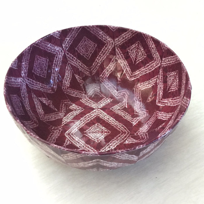 a paper mache bowl with red and white patterns