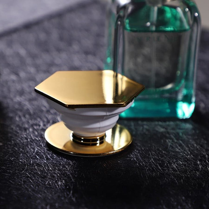 Gold expanding finger grip for phone and tablet by 9eight5, showing the adjustable grip with a sleek gold finish.