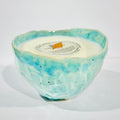 Handmade ceramic candle in a light blue and orange blossom scent, placed in a ceramic mug that can be used as a coffee/tea mug after the candle is finished.