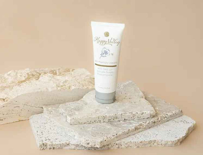 Bottle of Happy Valley Skin Therapy Cream by Happy Valley Honey, a soothing skincare product in a white container with a blue label.