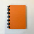 Orange spiral-bound notebook on a white background