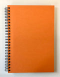 Orange spiral-bound notebook on a white background