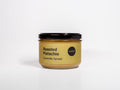 Jar of roasted pistachio caramelly spread on a white background