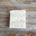 A white bar of laundry or dishwashing soap with 'Palm Free' and 'Irish Handmade' printed on it, placed on a wooden surface.