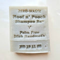 A white, solid-colored pet shampoo bar with 'ZERO WASTE' and 'For Hoof & Pouch' printed on it, indicating that it is palm free and made in Ireland.