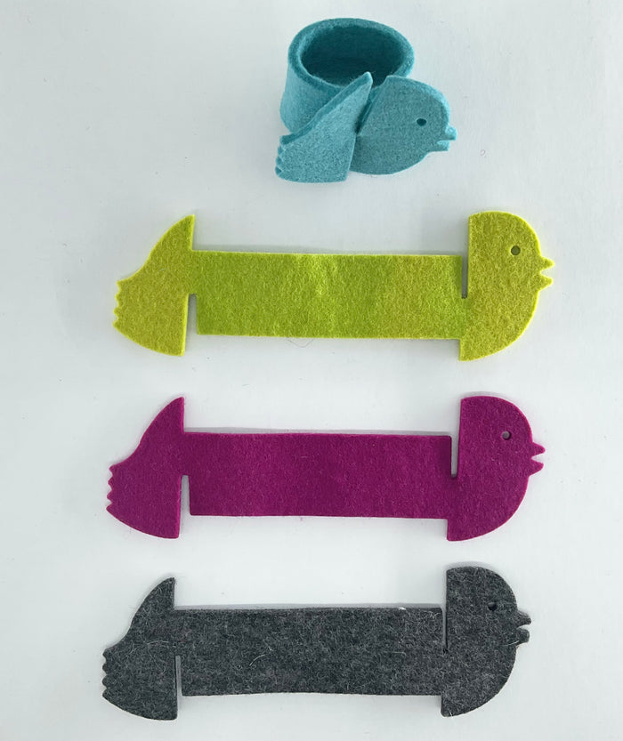 Colorful felt animal napkin holders on a white background