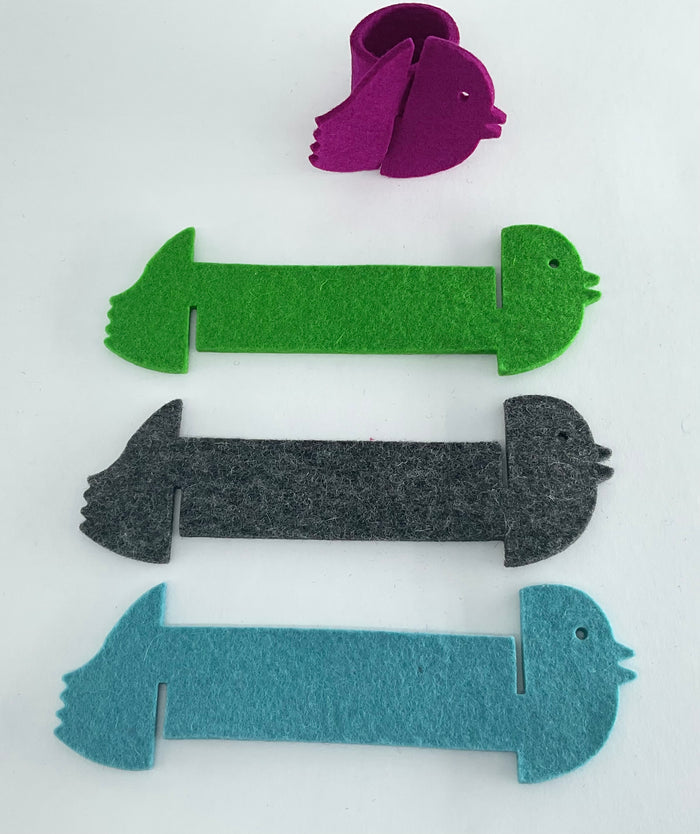Set of colorful felt animal napkin holders on a white background