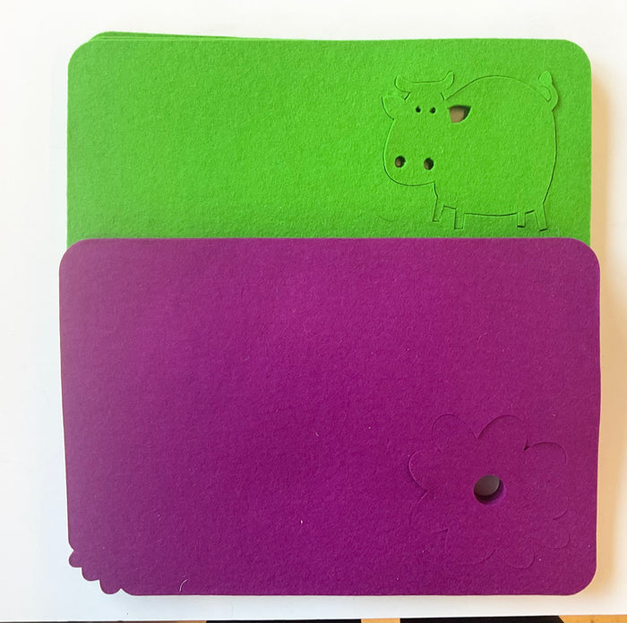 Green and purple wool placemat with a flower and cow design on a white background