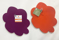 Two flower-shaped pot stands, one purple and one orange, with tags on a white background.