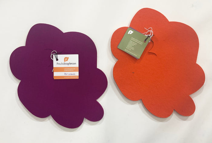 Two flower-shaped pot stands, one purple and one orange, with tags on a white background.