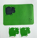 Green tea cosies and coasters with cow cutouts on a white background