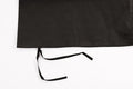 Black apron with long ties, made from durable fabric, perfect for cooking or crafting.