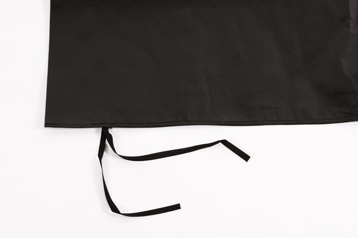 Black apron with long ties, made from durable fabric, perfect for cooking or crafting.