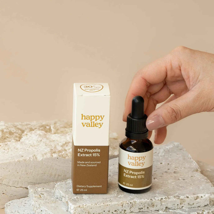 Bottle of Happy Valley Honey Propolis Extract NZ with golden liquid in a clear glass bottle.