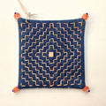 Decoratively stitched denim coaster with a geometric pattern and beads on each corner