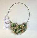 Necklace with green and gold beads on a white background