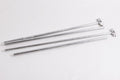 Set of four galvanized steel rods with T-shaped ends for durable construction and assembly.