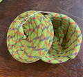 basket made from rope with a lid. rope is sewn with yellow thread, and woven together from blue, red, yellow and light green threads.