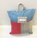 Blue pillow with a handle and a red and tweed pocket containing  a notebook and pen